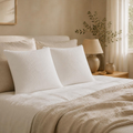 Duo d'oreillers mémoire de forme flocons JLB Home posés côte à côte sur un lit en linge écru